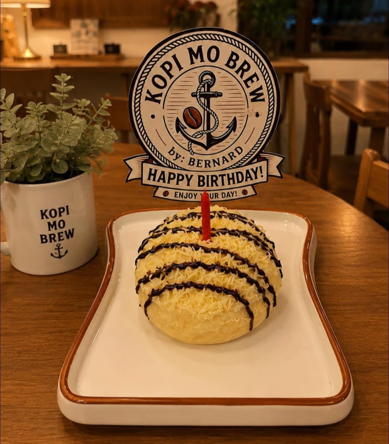 A cheese ensaymada with a single candle on a bread-shaped plate